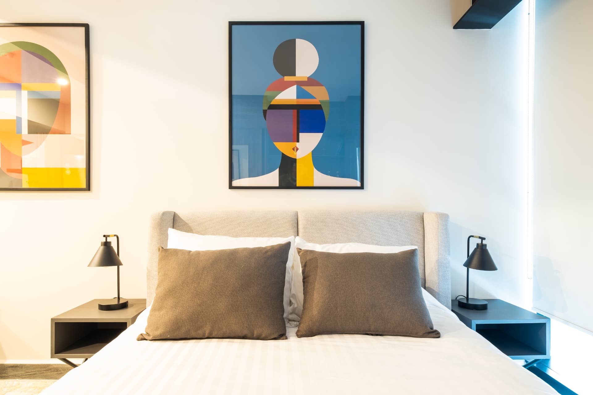 Recámara con cama, burós, cuadros y persianas