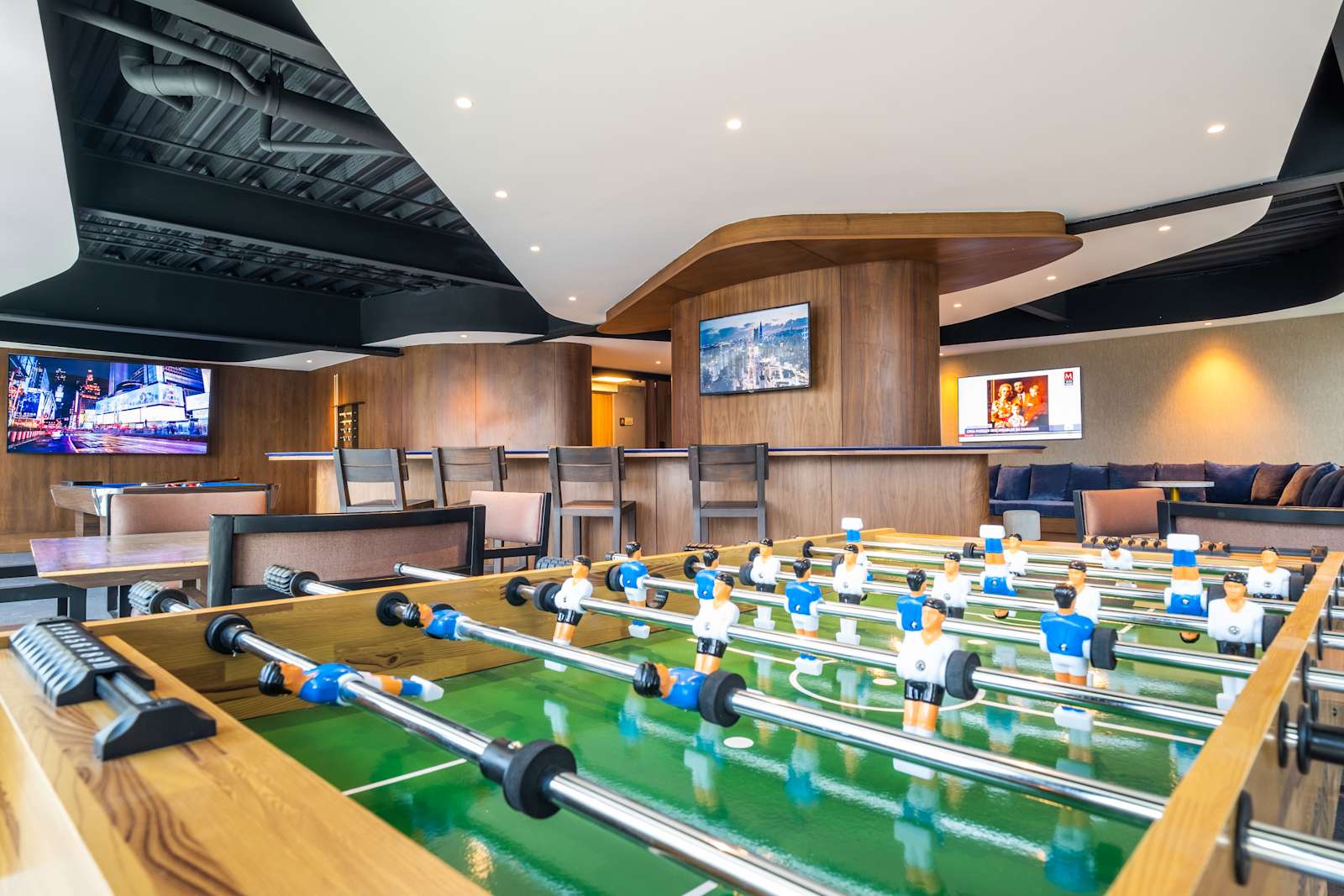 Mesas de futbolito y pantallas en el salón de juegos