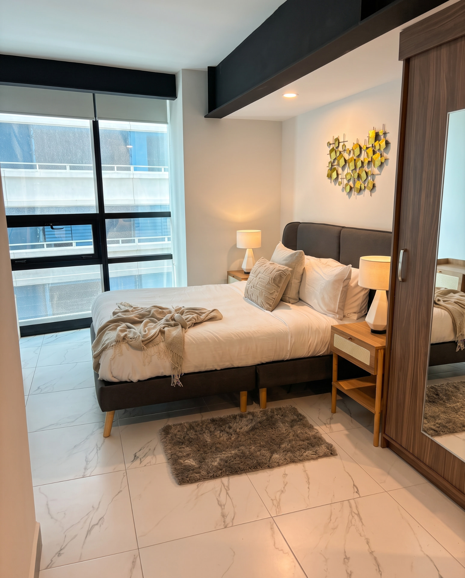 Recámara con cama matrimonial, buró y ventanal