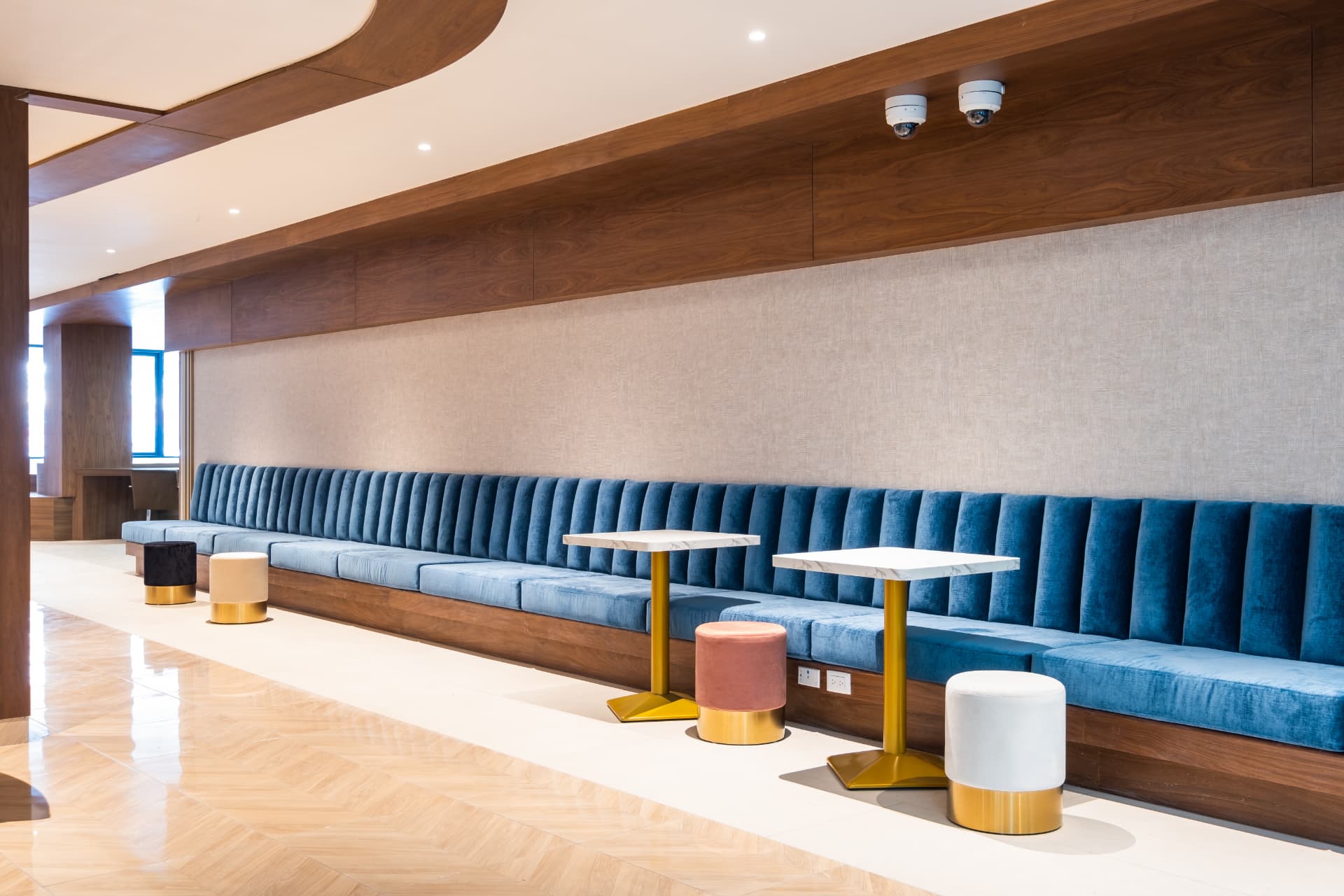 Cowork con sofá azul, mesas y acabados de madera