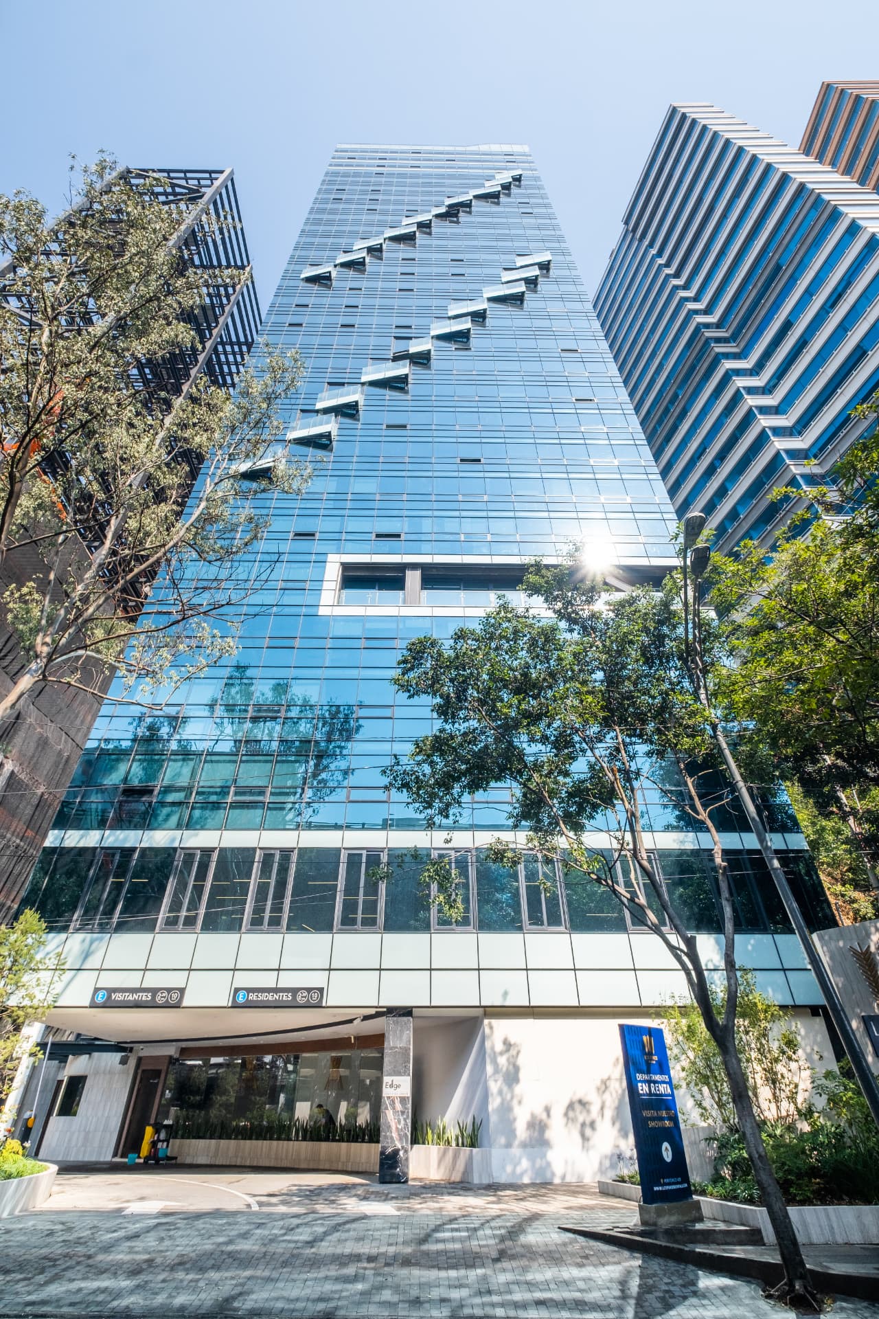 Fachada acristalada y acceso al edificio Los Pinos Rentals